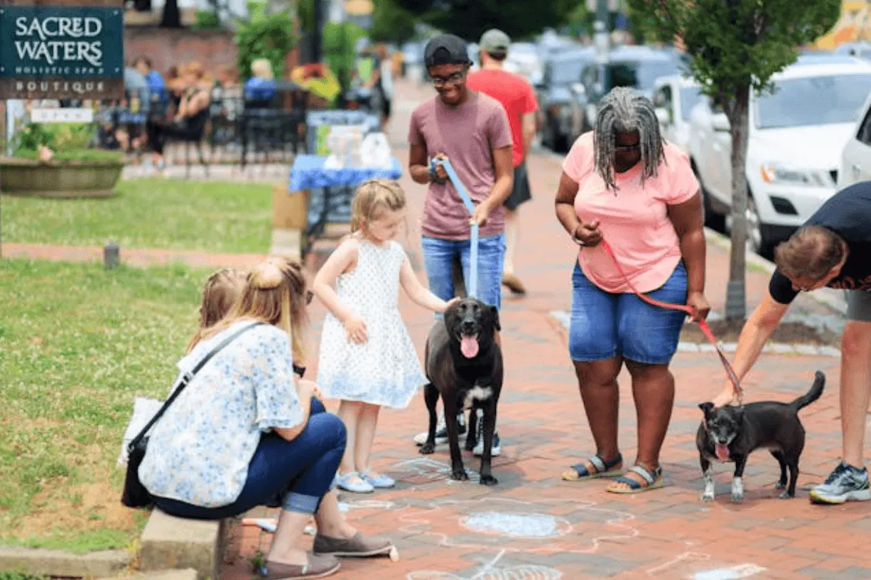 people in dog park with children
