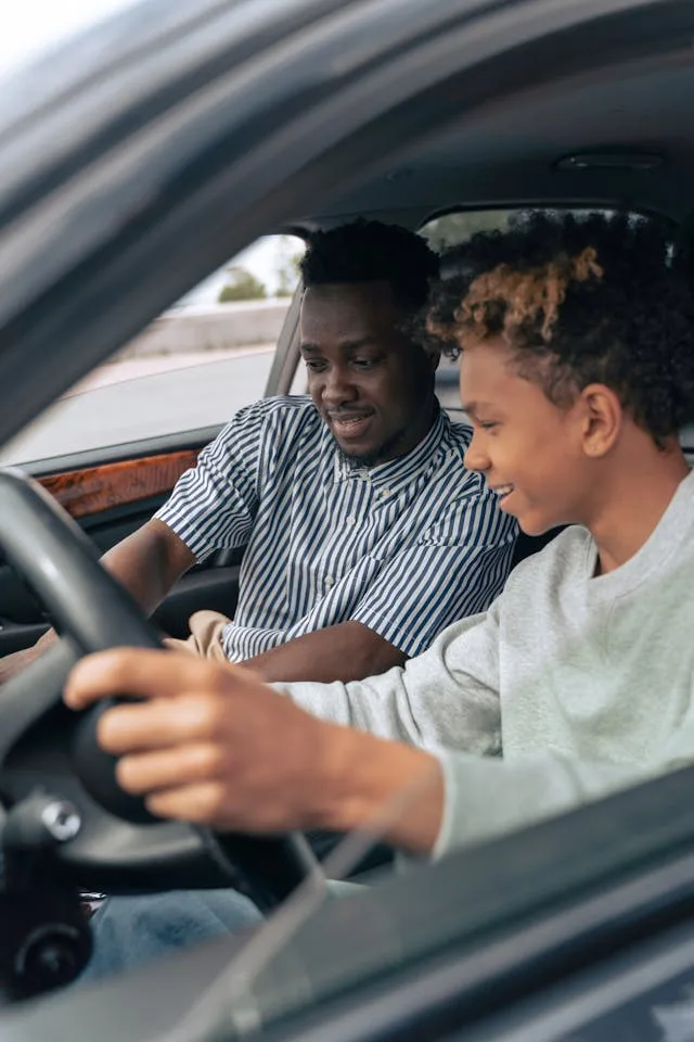 a parent teaching teen driver accidents courses to son in car