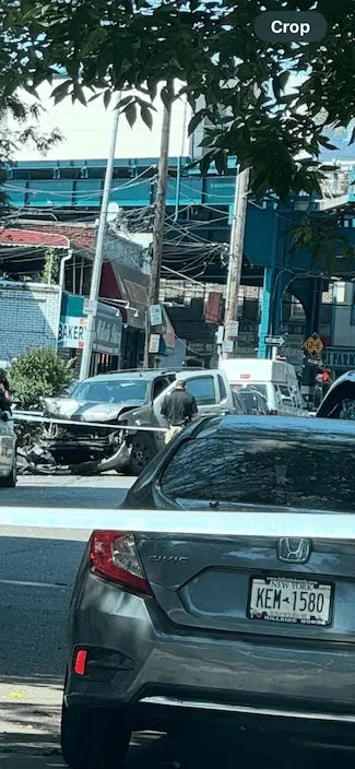 image of the aftermath of a fatal Elmhurst Queens sidewalk crash depicting the car the suspect was driving crashed onto the sidewalk