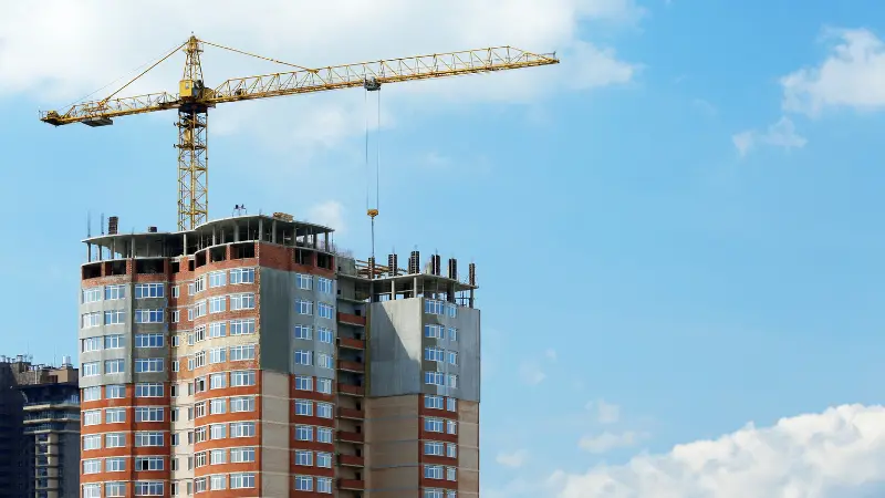 NYC crane accident risks shown with tower crane at Manhattan high-rise construction site, post-2023 collapse safety reforms