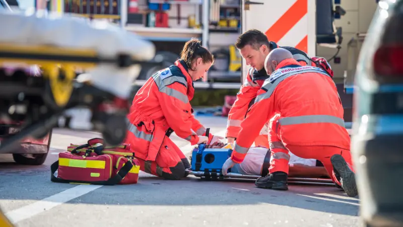 6 Facts Every New Yorker Should Know About Crash Responder Safety Week 2025: Three paramedics helping an injured man after a car accident