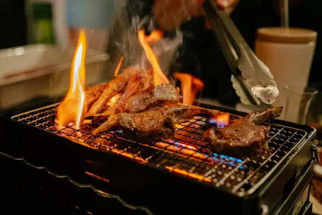 Las llamas abiertas en espacios cerrados suponen un riesgo de lesiones en las barbacoas en el jardín. En la imagen, una parrilla interior con llamas abiertas asando carne.