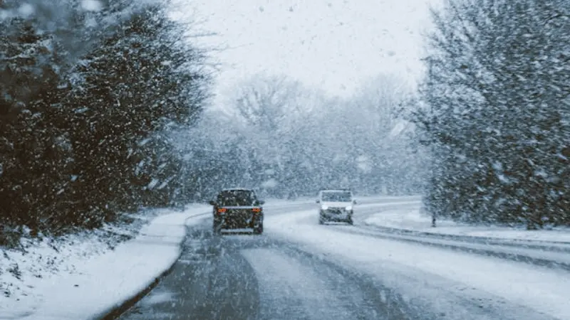 Coches circulando bajo una fuerte nevada.