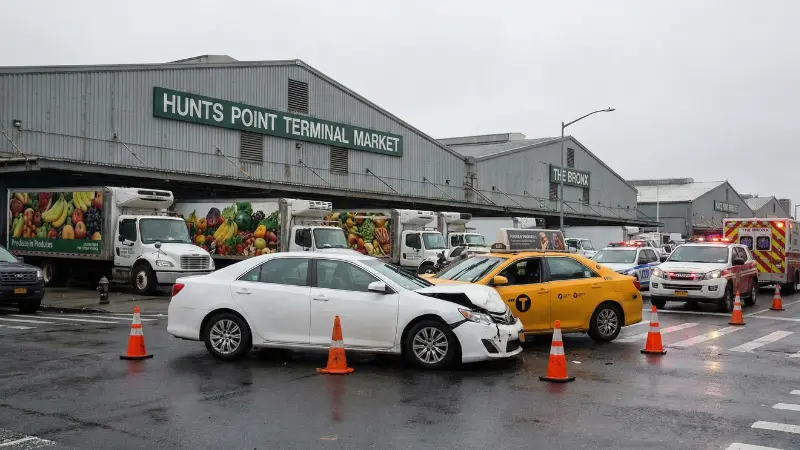 Scene of deadly Bronx car crash near Hunts Point Market involving sedan and taxi with emergency responders and cones blocking the road
