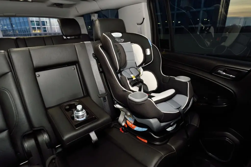 Imagen de la Semana de la Seguridad de los Niños Pasajeros en la que se ve una silla infantil de coche fijada en la parte trasera de un turismo aparcado.
