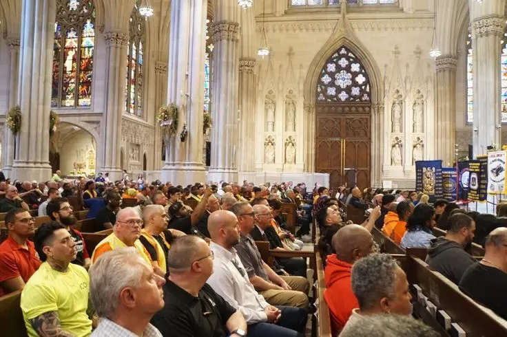 Construction workers and attendees gathered inside St. Patrick’s Cathedral wearing safety gear during memorial mass for injured and fallen workers