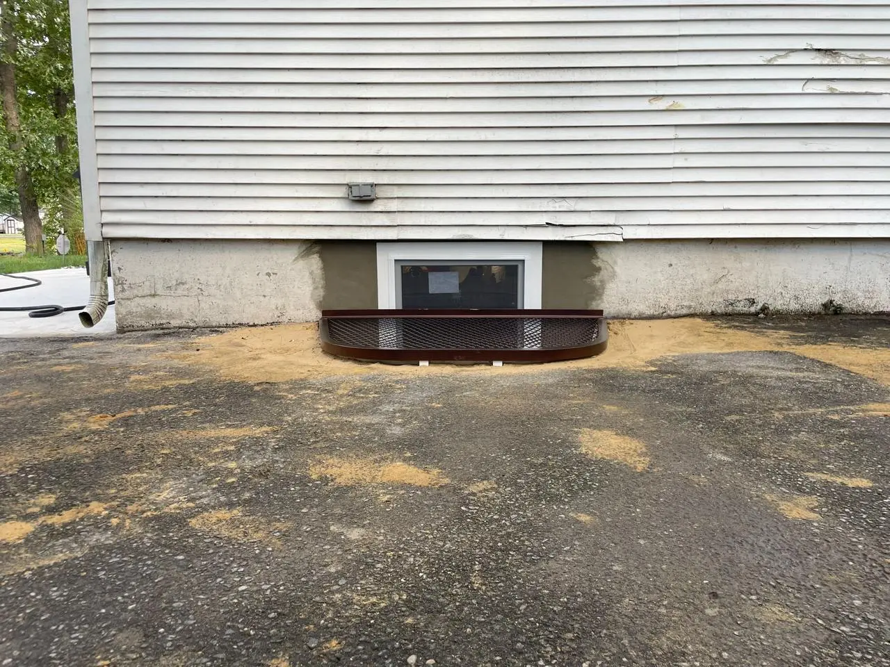 Egress window installation by A-1 Basement Solutions, showcasing a newly installed window with a protective well, enhancing basement safety and natural light.