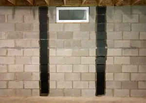Foundation repair using carbon fiber strips on basement wall, showcasing structural reinforcement techniques by A-1 Basement Solutions.