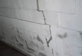 Cracked concrete wall indicating potential foundation problems, highlighting the importance of timely foundation repair methods for home stability.