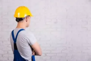 contractor looking at wall analizing 