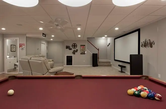 Cozy finished basement featuring a pool table, entertainment area with a large screen, and comfortable seating, ideal for family gatherings and leisure activities.