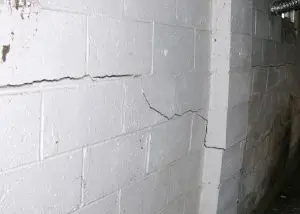 Cracked foundation wall indicating structural damage and potential risk of collapse.
