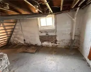 Basement interior showing water damage, mold growth, and peeling paint, highlighting common issues in basement repair and maintenance.