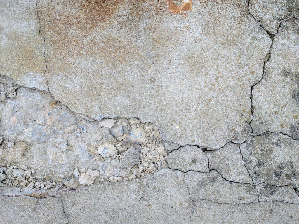 Cracked concrete surface highlighting foundation damage, emphasizing the need for timely foundation repair to prevent structural collapse.