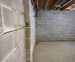 Interior view of a basement with cinder block walls, highlighting potential foundation repair needs related to underpinning and structural stability.