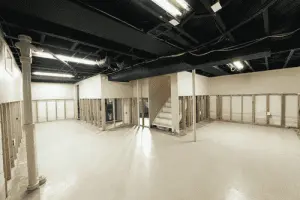 Empty basement space with exposed walls and columns, illustrating a potential area for basement waterproofing and repair solutions.