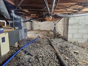 Crawl space with exposed soil, pipes, and moisture issues causing sagging floors and poor air quality