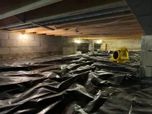 Crawl space with vapor barrier installation to prevent moisture damage and protect floor structure in an Indiana home