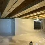 Completed crawl space encapsulation in Indianapolis, IN featuring a sealed white vapor barrier, insulated foundation walls, and a clean, moisture-controlled crawl space.