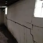 Cracked basement wall highlighting structural damage, emphasizing the need for professional wall repair services from StablWall.