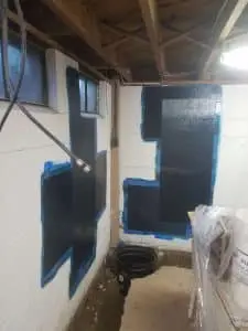 Carbon fiber straps reinforcing a cracked concrete block basement wall during Rockville foundation repair to stabilize structural movement.