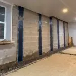 Foundation wall with carbon fiber reinforcement strips, illustrating professional foundation crack repair methods by StablWall.