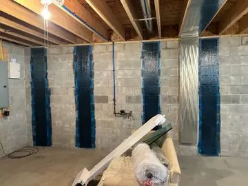 Interior view of a crawlspace with carbon fiber reinforcement applied to concrete walls, highlighting structural repair techniques by StablWall.
