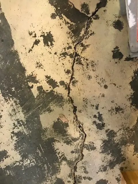 Concrete floor with visible crack, illustrating the need for repair solutions using StablWall's carbon fiber technology.