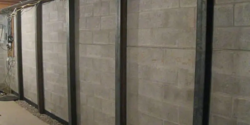 Bowed basement walls reinforced with steel beams, illustrating foundation repair techniques relevant to cost discussions in basement wall repairs.