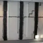 Basement wall with carbon fiber strips applied for crack repair, demonstrating strength and durability for structural integrity restoration.