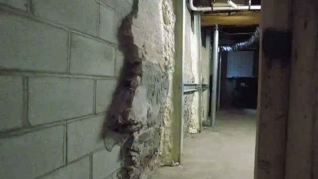 Bowed basement wall showing significant inward curvature and damage, highlighting structural issues related to hydrostatic pressure.