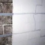 Bowing foundation wall with visible cracks and discoloration, highlighting structural damage concerns related to basement safety and the need for professional repair services.