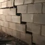 Cracked concrete block wall indicating foundation issues, relevant to foundation repair discussions.
