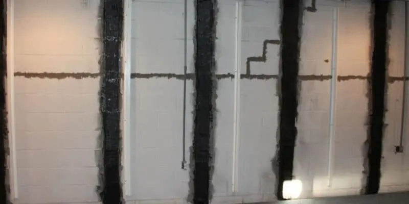 Carbon fiber strips applied to basement foundation walls, showcasing StablWall’s innovative reinforcement technology for foundation repair.