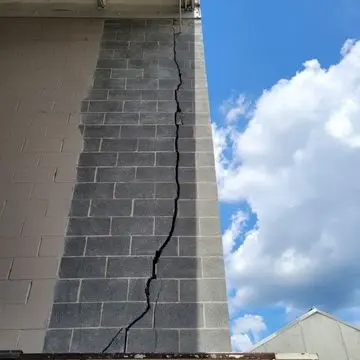 Cracked foundation wall showing significant vertical damage, highlighting the importance of foundation repair solutions like carbon fiber reinforcement.