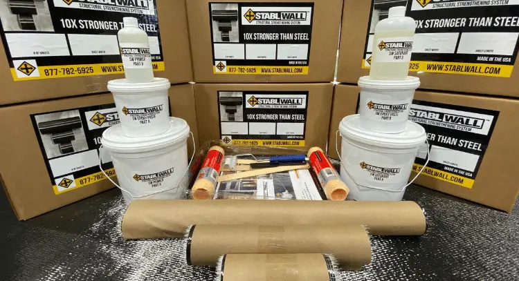 StablWall foundation repair kit components including buckets, tools, and informational materials, showcasing a cost-effective solution for cracked foundations, emphasizing strength ten times greater than steel.