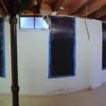 Basement wall with carbon fiber straps installed for foundation repair, addressing issues of pushed walls and hydrostatic pressure.