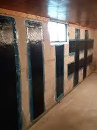 Foundation wall with reinforced crack repair, showcasing black epoxy application and structural support, relevant to foundation stability and repair methods.