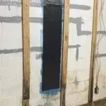 Foundation wall with carbon fiber reinforcement applied, showcasing structural repair process for enhanced durability and stability.