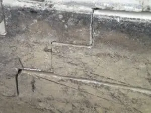 Cracked foundation wall showing signs of structural damage, relevant to foundation repair techniques such as wall repairs and crack injections.