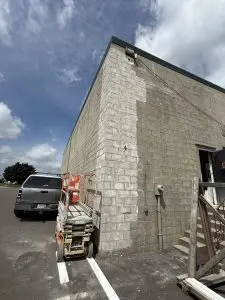 Concrete wall showing foundation repair work with scaffolding and equipment, illustrating structural maintenance related to foundation cracks.