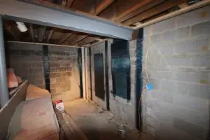 Carbon fiber foundation repair straps permanently reinforcing a cracked basement wall to prevent further movement.