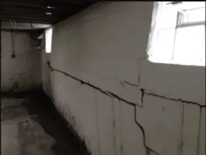 Horizontal crack running across a basement wall showing structural pressure and potential foundation damage