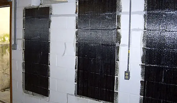 Carbon fiber straps installed on foundation walls for reinforcement against bowing and structural issues in a basement setting.
