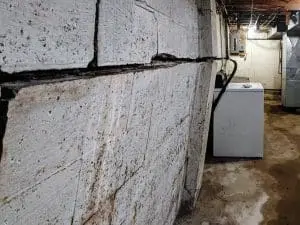 horizontal crack in basement wall showing bowing caused by soil and hydrostatic pressure