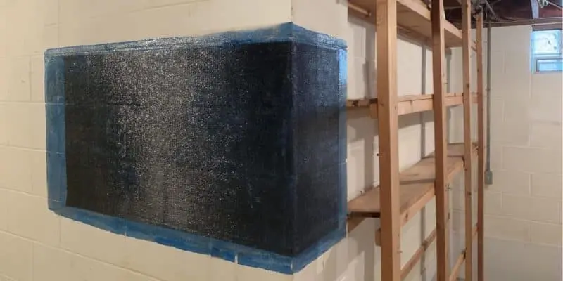 Carbon fiber straps installed on a basement wall to reinforce and stabilize foundation cracks.
