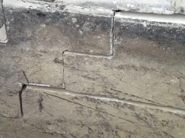 Cracked foundation wall showing signs of structural damage, relevant to foundation repair techniques such as wall repairs and crack injections.