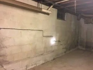 Stair-step cracks in basement wall showing foundation damage in Roanoke VA home