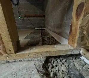 Interior basement drainage system installation with gravel trench and wall channel