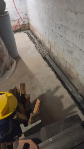 Sub-floor drainage system installed along basement wall in Newport VA to stop water intrusion and protect the foundation